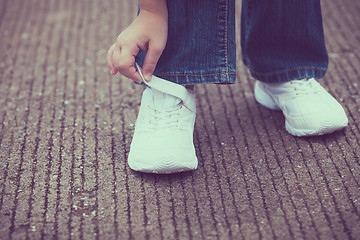 Image showing youth sneakers on girl legs on road