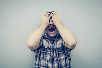 Image showing portrait one sad man standing near a wall and covers his face