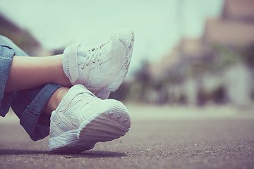 Image showing youth sneakers on girl legs on road