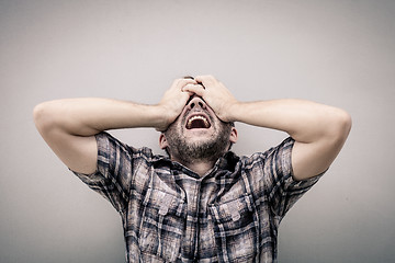 Image showing portrait one sad man standing near a wall and covers his face