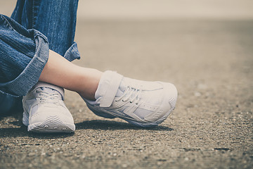 Image showing youth sneakers on girl legs on road