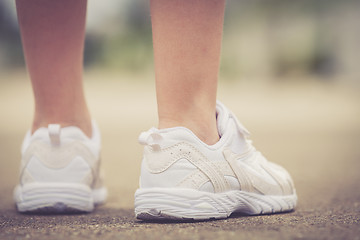Image showing youth sneakers on girl legs on road