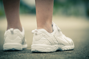 Image showing youth sneakers on girl legs on road