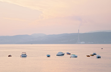 Image showing Sea boats at sunset from Omisali,  Rijeca (Fiume) and Bakar refinery in the background, Krk island, Dalmatia, Croatia