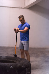 Image showing man workout with hammer and tractor tire