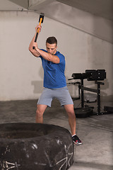 Image showing man workout with hammer and tractor tire