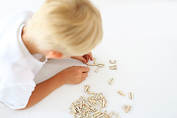 Image showing Child on impact string of wooden letters