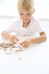 Image showing Educational fun, little boy puts puzzle.