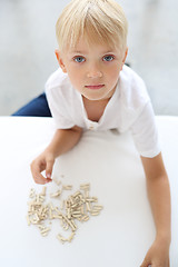 Image showing Learning to write. The child puts words with letters.