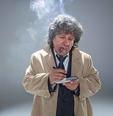 Image showing The senior man as detective or boss of mafia on gray studio background