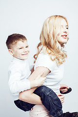 Image showing young modern blond curly mother with cute son together happy smiling family posing cheerful on white background, lifestyle people concept, sister and brother friends