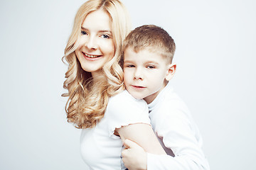 Image showing young modern blond curly mother with cute son together happy smiling family posing cheerful on white background, lifestyle people concept, sister and brother friends