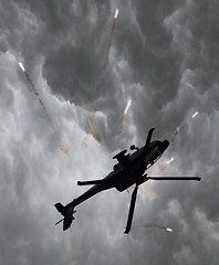 Image showing Silhouette of an attack helicopter firing flares