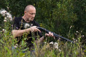 Image showing hunter with a gun among the grass