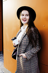 Image showing young pretty hipster girl student with coffee cup posing adorable smiling, lifestyle people concept outdoor