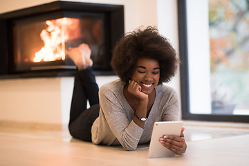 Image showing black women using tablet computer on the floor