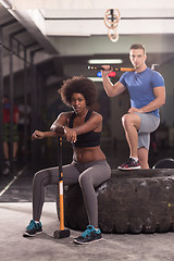 Image showing multiethnic couple after workout with hammer