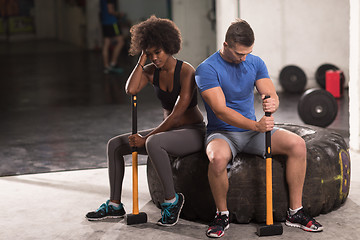 Image showing multiethnic couple after workout with hammer