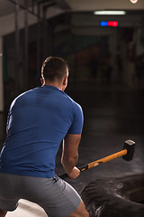 Image showing man workout with hammer and tractor tire