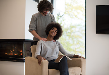 Image showing multiethnic couple hugging in front of fireplace