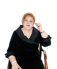 Image showing Senior woman putting hearing aid on.