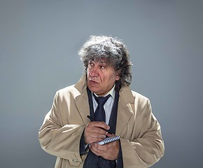 Image showing The senior man as detective or boss of mafia on gray studio background