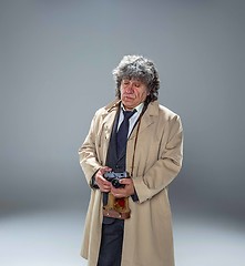 Image showing The senior man as detective or boss of mafia on gray studio background