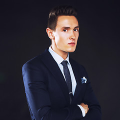 Image showing young pretty business man standing on black background, modern h