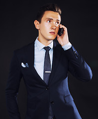 Image showing young pretty business man standing on black background, modern h