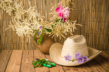 Image showing Straw hat and flowering campanula, close-up