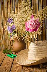 Image showing Straw hat and peony flower, close-up