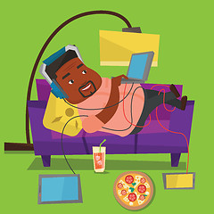 Image showing Man lying on sofa with many gadgets.