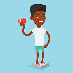 Image showing Man standing on scale and holding apple in hand.