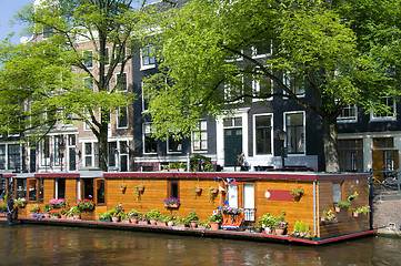 Image showing amsterdam holland canal house boat with flowers