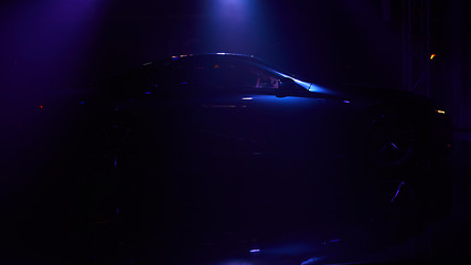 Image showing Silhouette of car with headlights on black background.