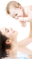 Image showing laughing blue-eyed baby playing with mom