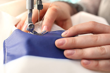 Image showing Sewing underwear. Woman sewing on the sewing machine