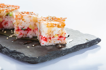 Image showing set of sushi on a slate square plate. 