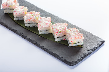 Image showing set of sushi on a slate square plate. 