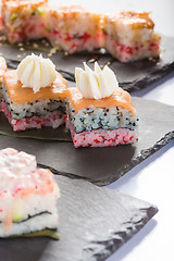 Image showing set of sushi on a slate square plate. 