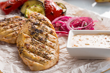 Image showing Grilled chicken breast with fries and salad