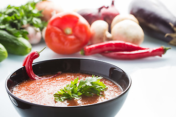 Image showing tomato soup in a black plate. 