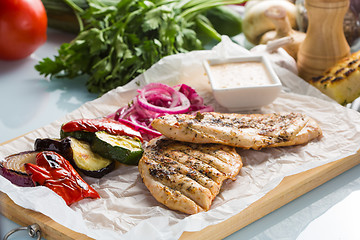 Image showing Grilled chicken breast with fries and salad