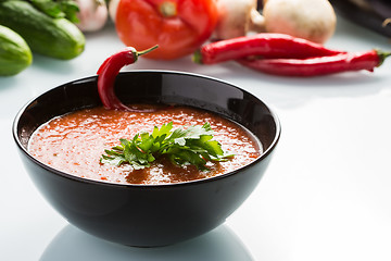 Image showing tomato soup in a black plate. 