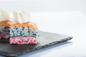 Image showing set of sushi on a slate square plate. 