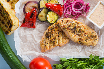 Image showing Grilled chicken breast with fries and salad