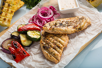 Image showing Grilled chicken breast with fries and salad
