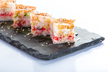 Image showing set of sushi on a slate square plate. 