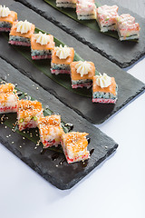 Image showing set of sushi on a slate square plate. 