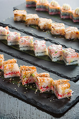 Image showing set of sushi on a slate square plate. 